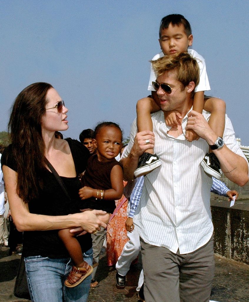 Angelina Jolie talking to Brad pitt who has his son Maddox on his shoulders