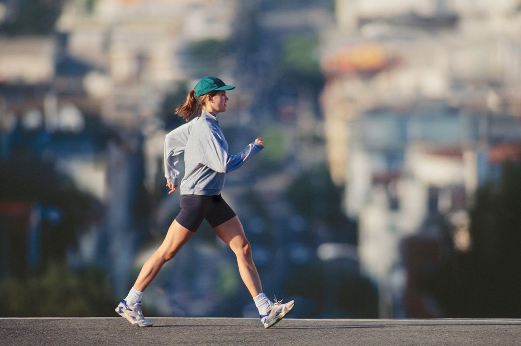Young woman powerwalking in urban area, profile