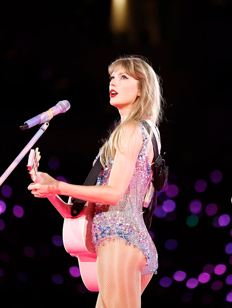 Taylor Swift on stage playing her guitar