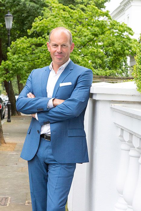 Phil Spencer with his arms crossed in a blue suit