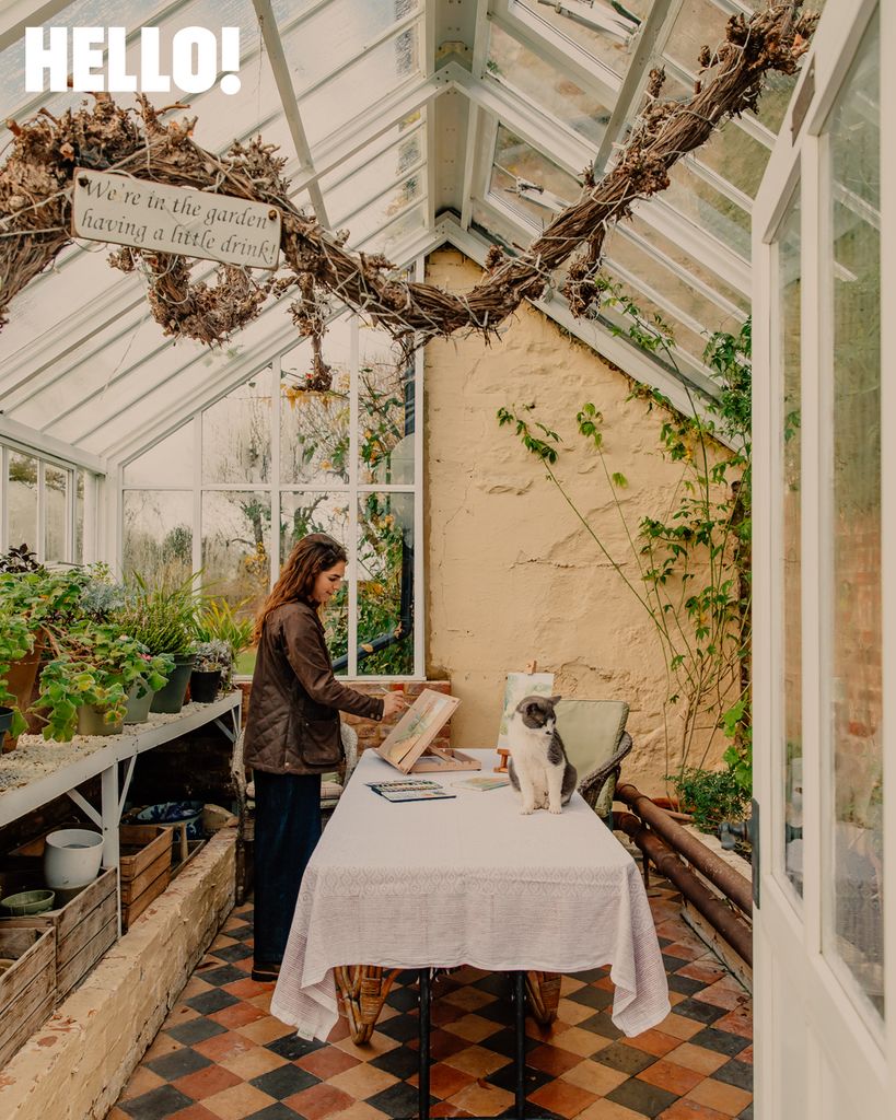 Olympia paints in the studio with Simba the cat