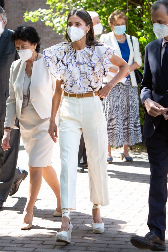 Queen Letizia wearing a white patterned blouse by Psophia and white trousers