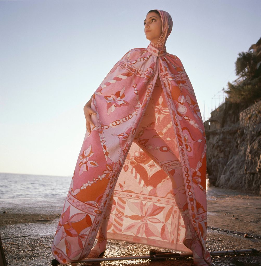 Model wearing a head-to-toe leotard in pink silk jersey and a long, terrycloth cape by Pucci.
