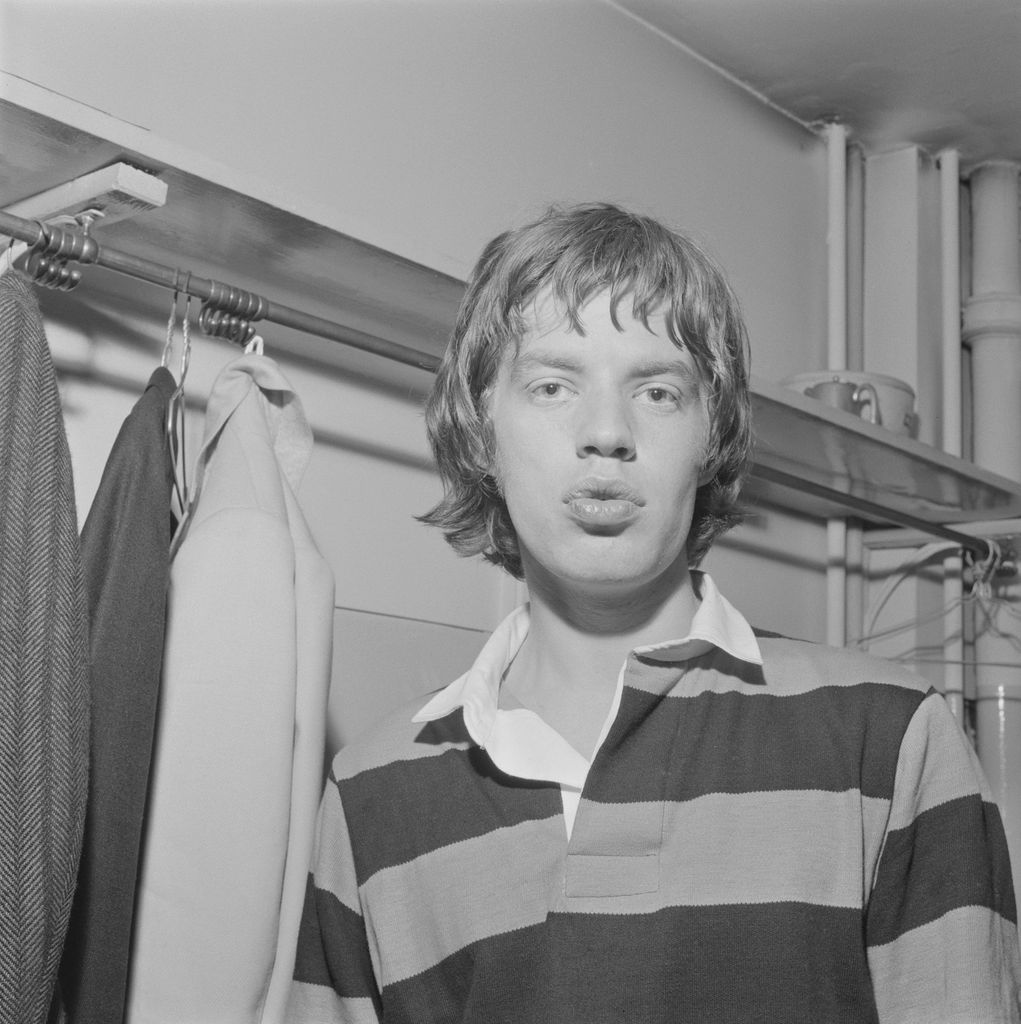 Mick Jagger wearing a rugby jersey backstage on tour in Scotland in early 1964