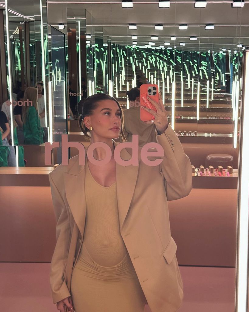 Hailey Bieber pregnant wearing baby bump enhancing beige bodycon dress and blazer