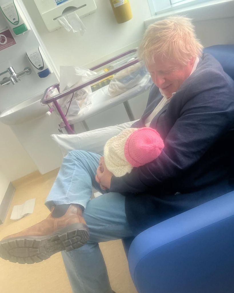 man holding baby with pink hat