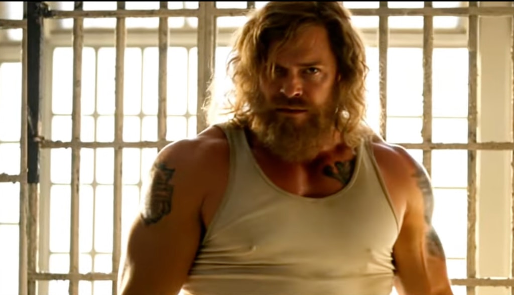 Alan with long hair for Motor City wearing vest in jail