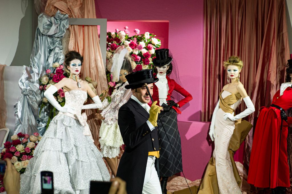 John Galliano pictured with models wearing his creations for Dior