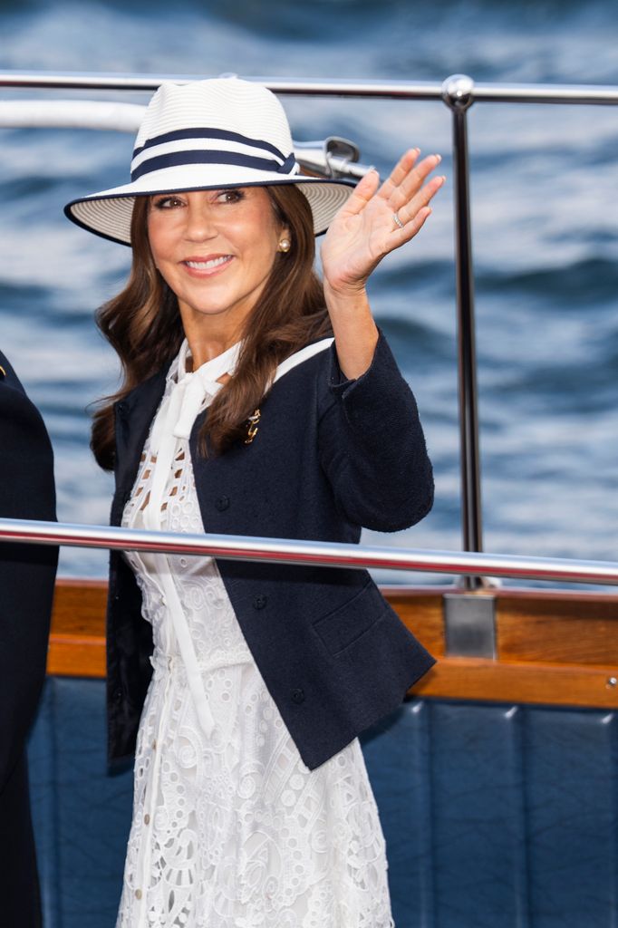 Queen Mary waving on ship in white dress