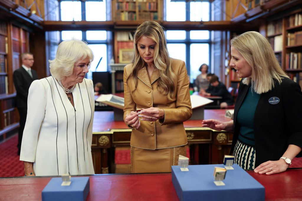 Queen Camilla, Melania Trump and a lady looking at a tiny book