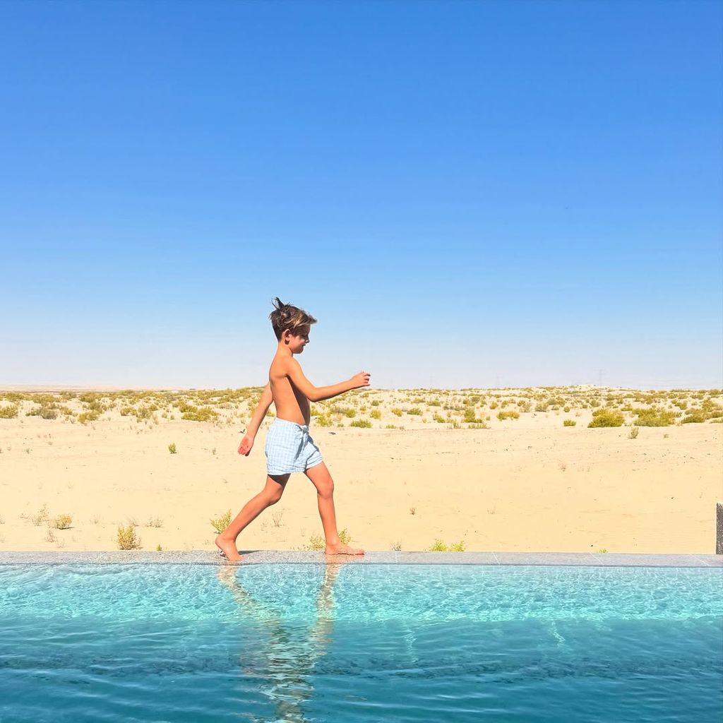 Storm Keating's son walking next to a pool