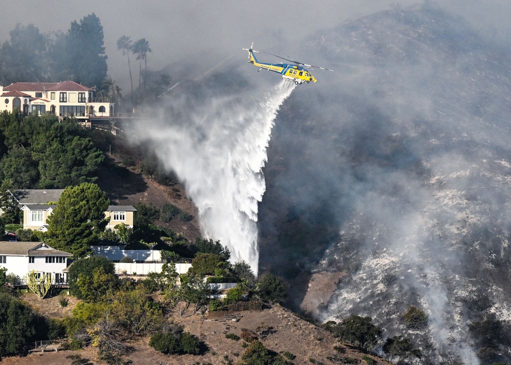 Helicopters battle flames as Palisades Fire burns on the Santa Monica Mountains 