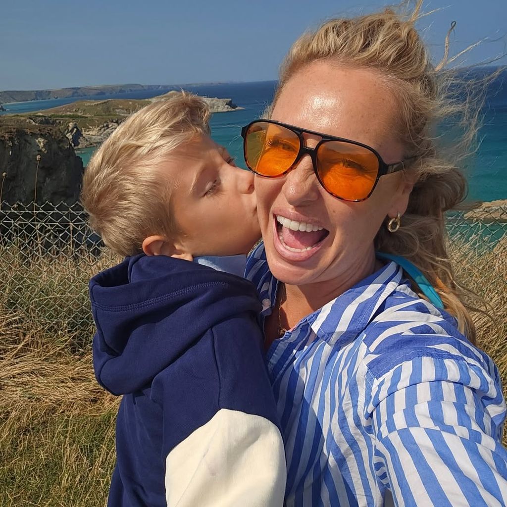 A boy and a woman standing in front of the sea