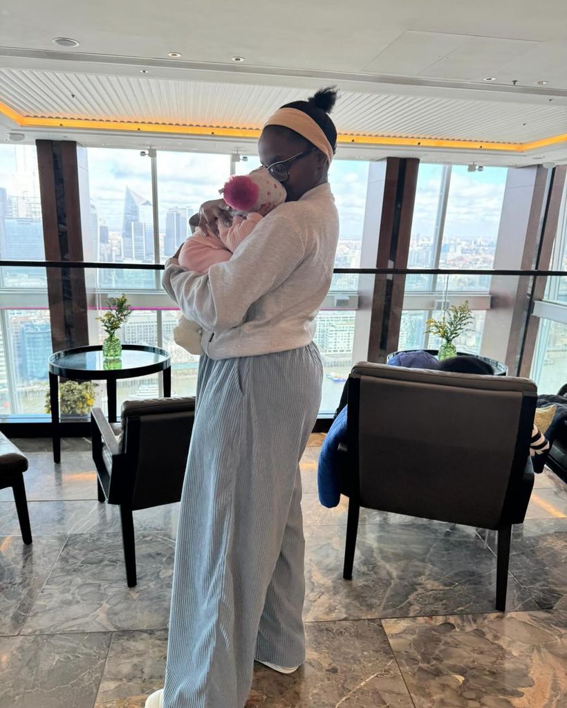 Oti Mabuse in casual sweatpants cradling baby daughter