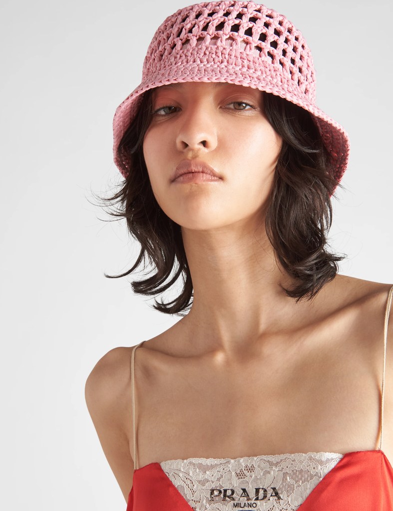 A model wears a pink crochet bucket hat from Prada