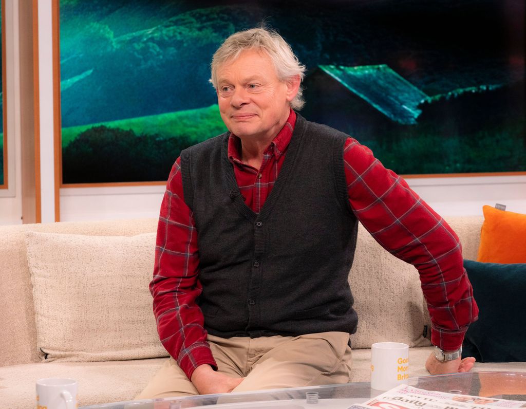 Man in red shirt sitting on sofa in tv studio