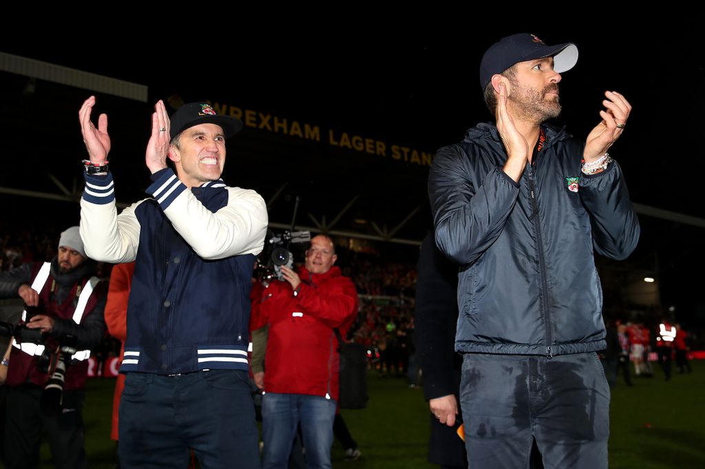 Ryan and Rob clap on the field after Wrexham's promotion