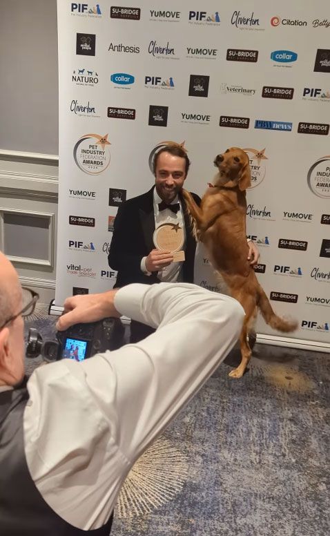 James Middleton holding an award alongside a brown dog