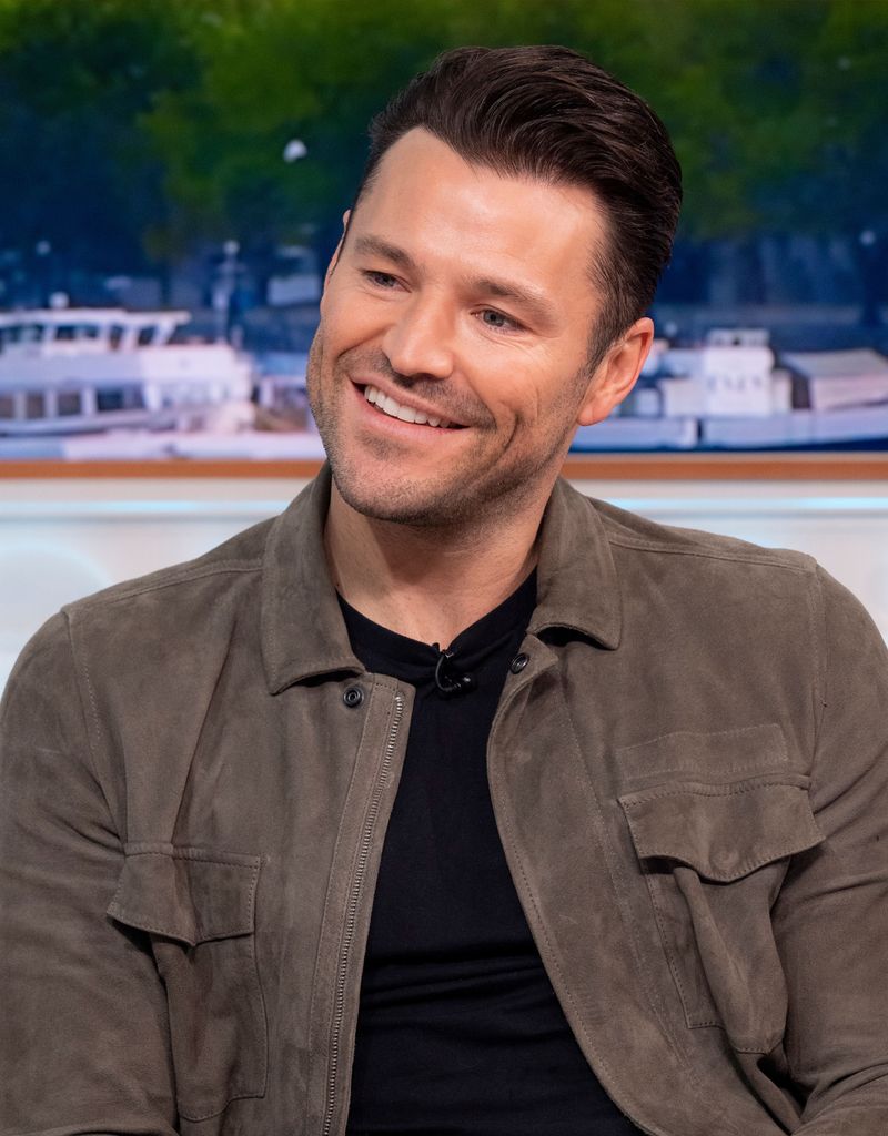 Mark Wright in brown jacket and black top