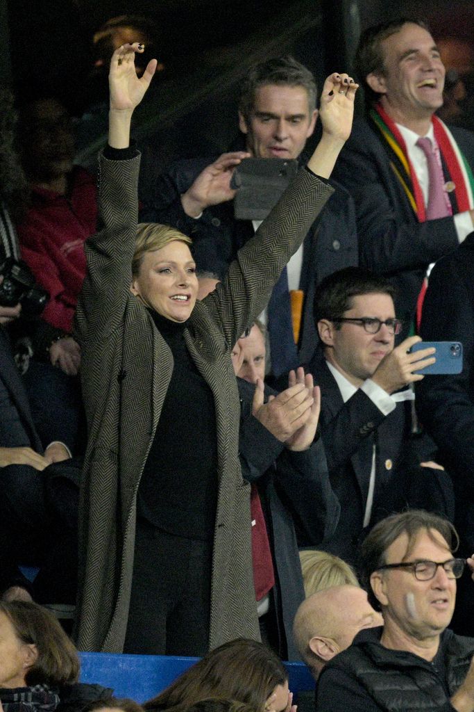 Princess Charlene of Monaco celebrates with her arms in the air