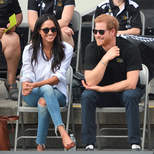 meghan and harry dressed casually in jeans and shades in the front row of a spots match
