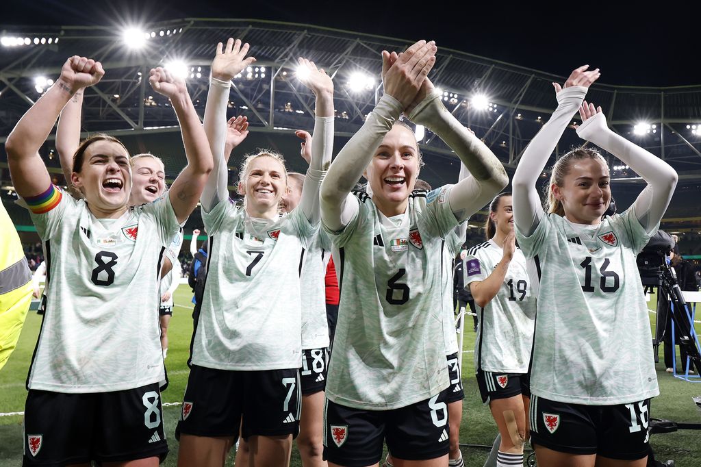 Josie Green and her Wales teammates celebrating clapping on pitch