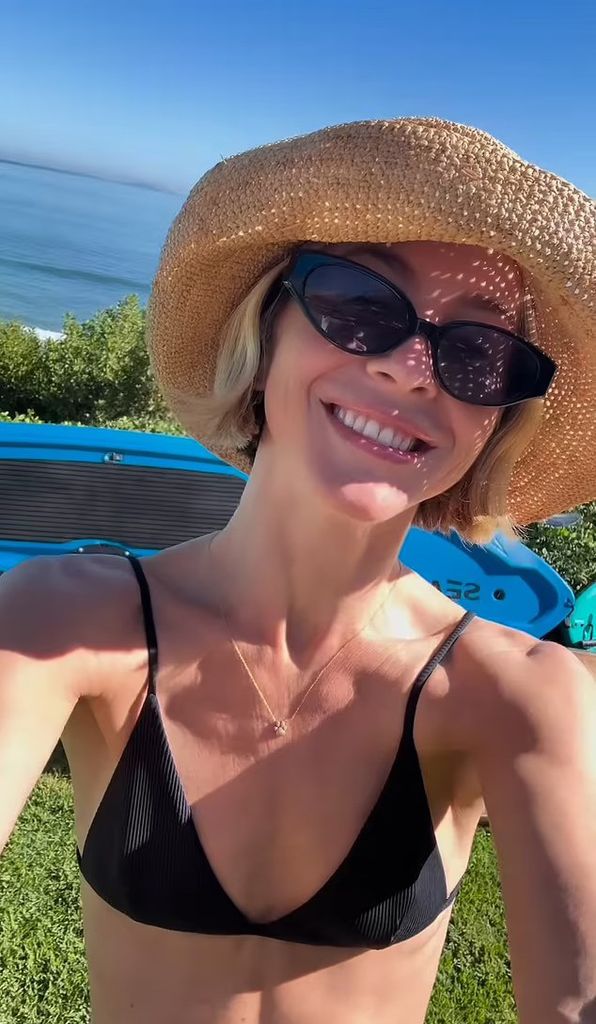 julianne hough smiling at camera in bikini sunglasses and straw hat