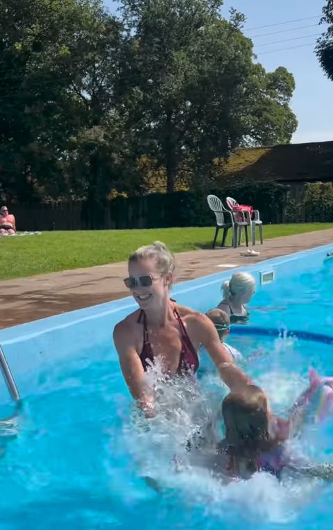 A young girl diving into a rubber ring shaped like a unicorn