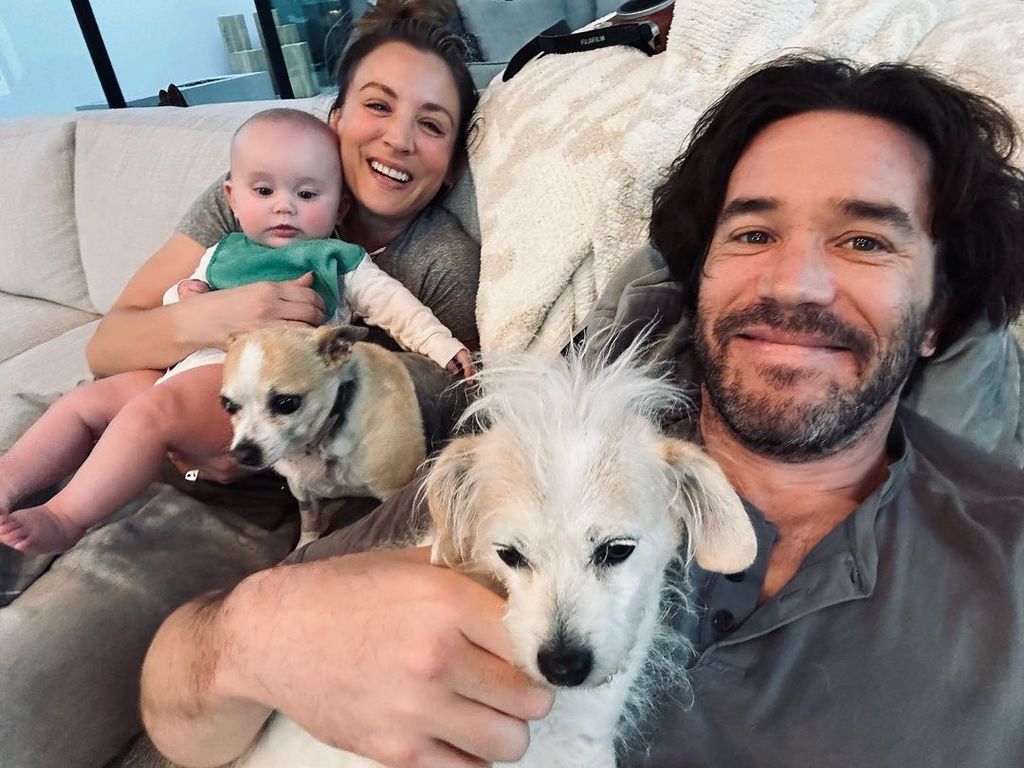 Kaley Cuoco with husband Tom Pelphrey, baby daughter and two dogs on sofa
