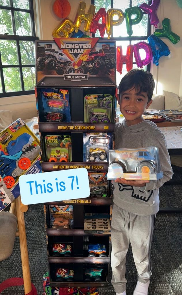 Jessica Alba's son in front of a tower of toy cars