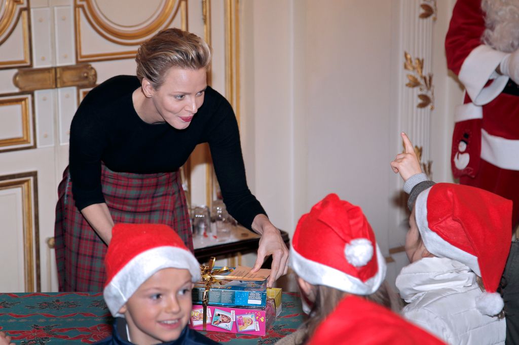 Prince of Monaco's wife Charlene gives gifts to children during a Children's Christmas ceremony on December 18, 2013 at the Monaco Palace. 