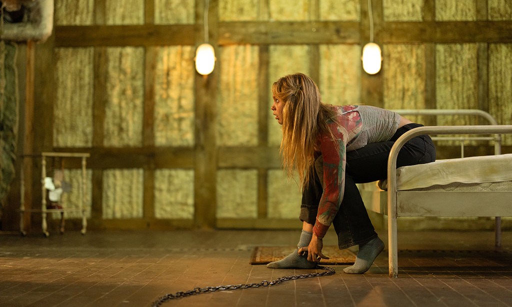 girl with chain around angle sitting on bed