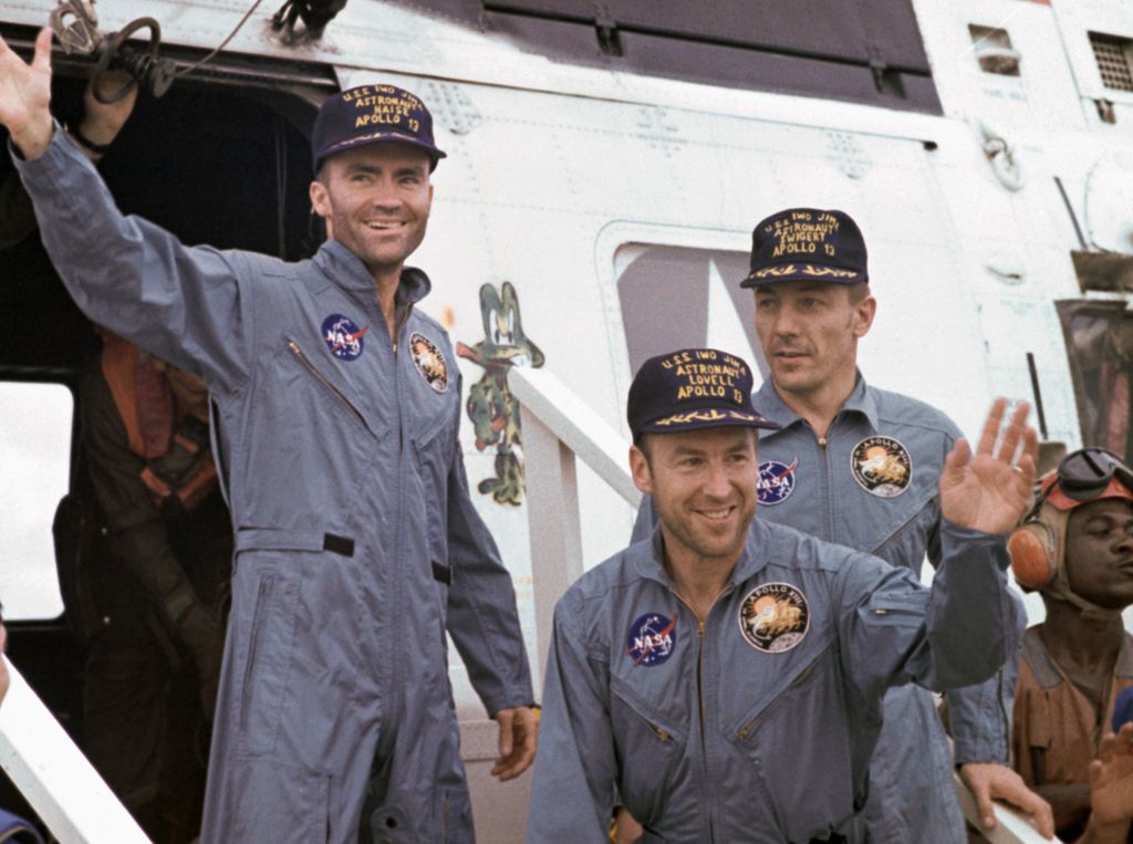 After splashdown, Apollo 13 astronauts arrive by helicopter on deck of the carrier USS Iwo Jima. Left to right: Fred Haise, James Lovell, and John Swigert