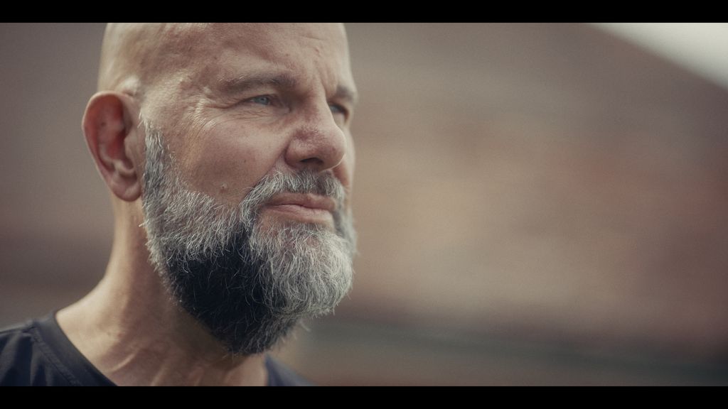 A still image of a bearded man