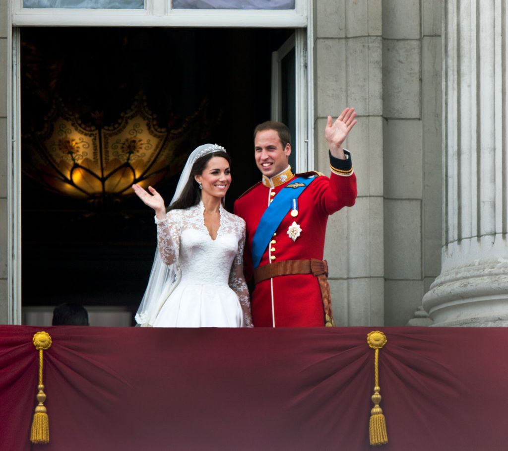 Prince William and Kate Middleton in their wedding outfits waving from Buckingham Palace's balcony