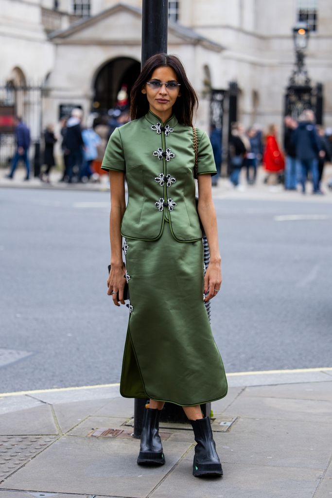 Karimah exuded opulence in a silk green co-ord green and black boots for the Huishan Zhang show.