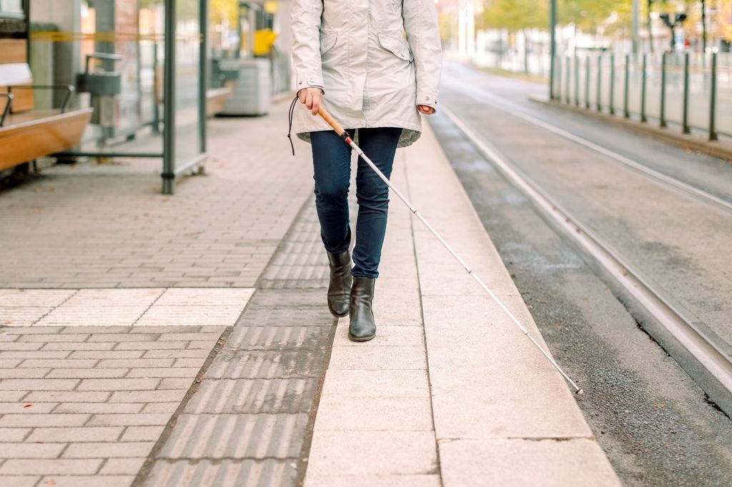 woman walking with cane on platform