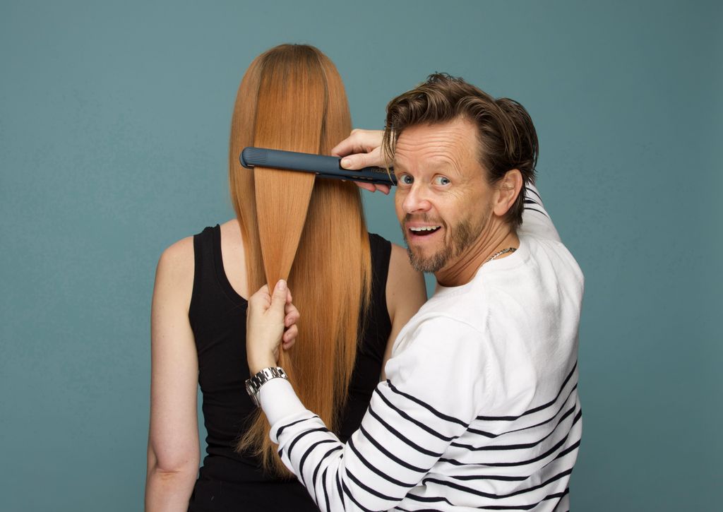 hairstylist michael douglas straightening a woman's long ginger hair