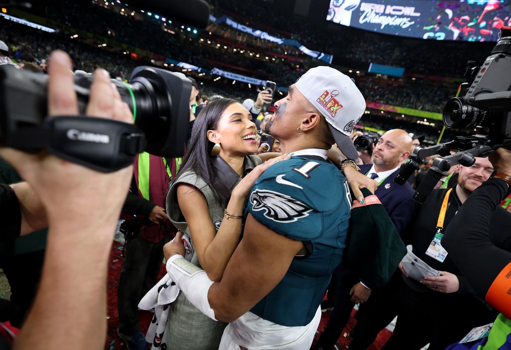 Jalen Hurts #1 of the Philadelphia Eagles and fiancee, Bry Burrows, embrace after defeating the Kansas City Chiefs 40-22 to win Super Bowl LIX 