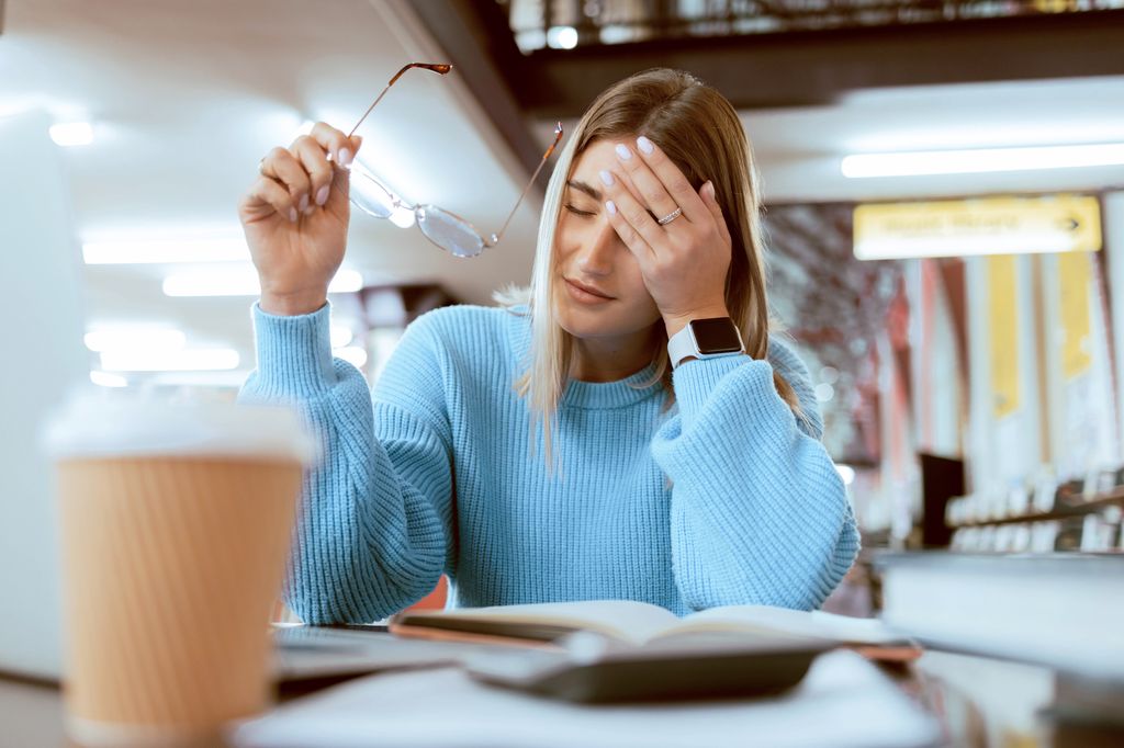 Woman looking stressed in a blue jumper