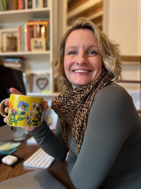 woman with a yellow mug wearing a leopard print scarf