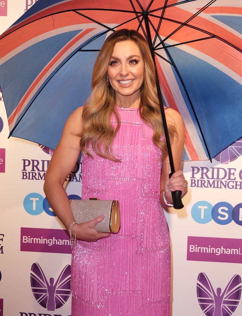 Amy Dowden in pink dress holding an umbrella