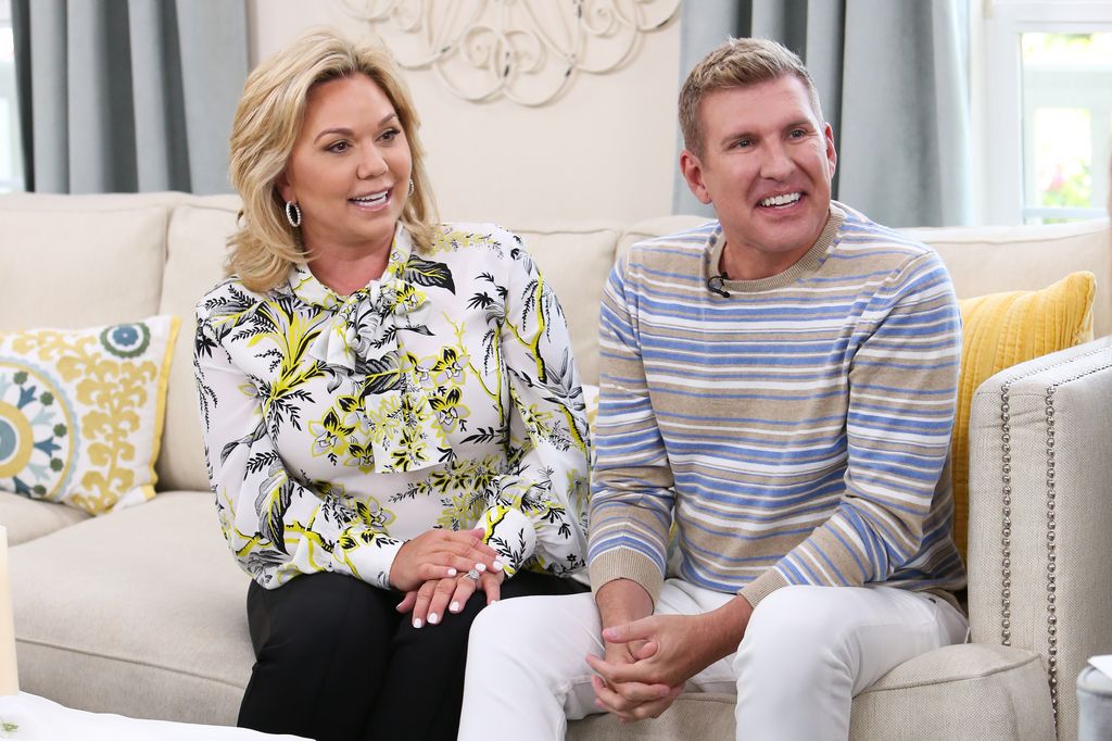 Reality TV Personalities Julie Chrisley (L) and Todd Chrisley sit on a sofa