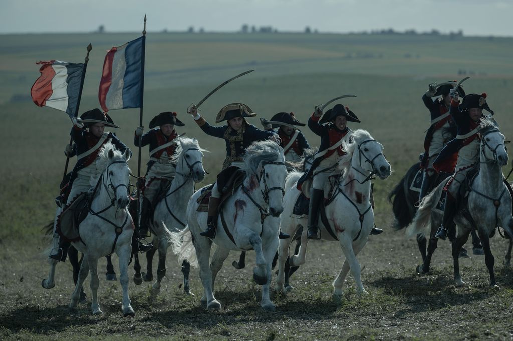 Joaquin Phoenix and cast on horses in still from Napoleon