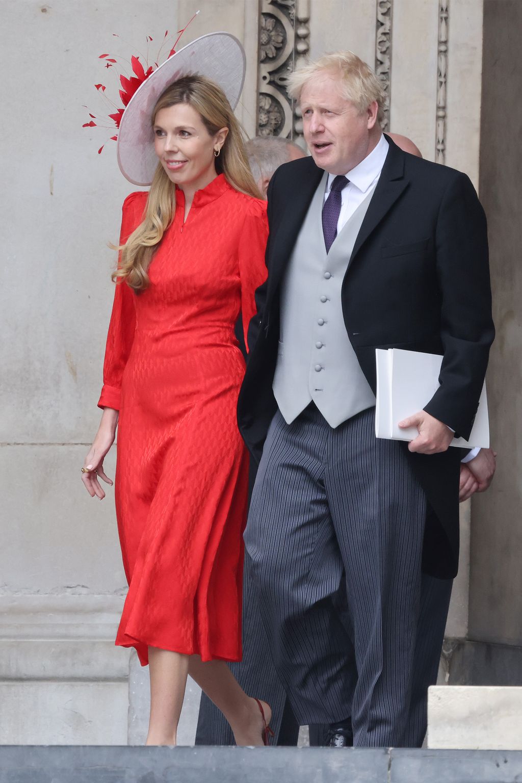 Boris Johnson in a suit and Carrie in red dress leaving St Paul's Cathedral