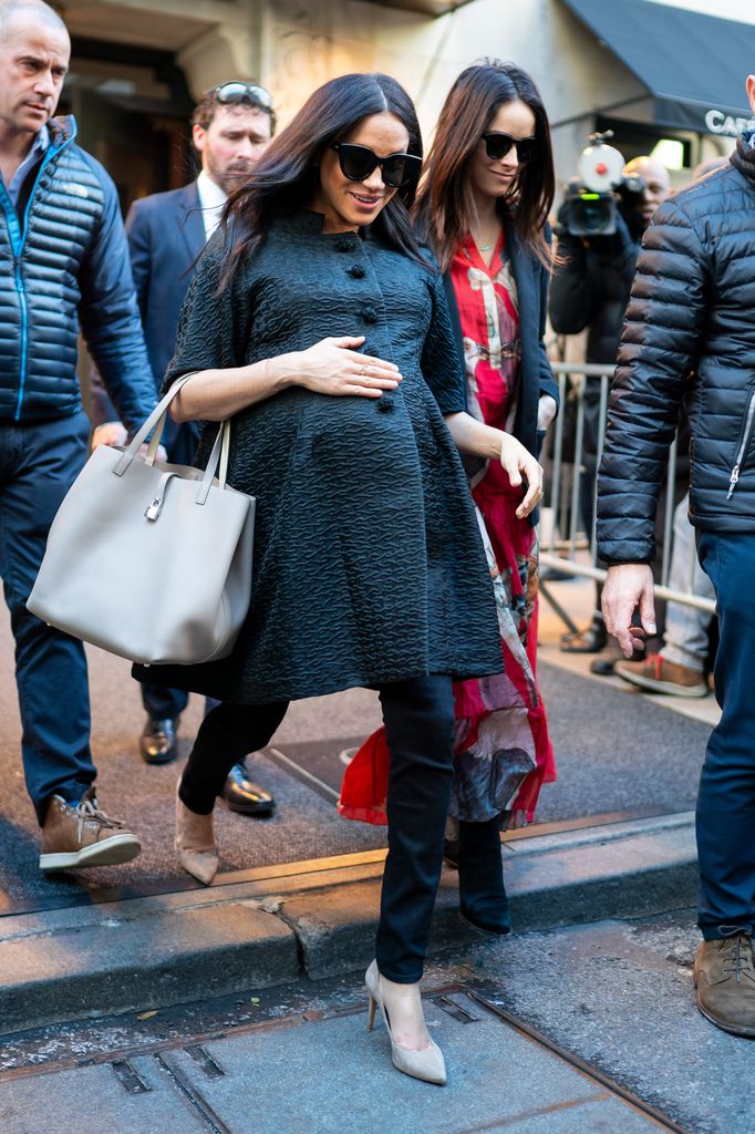 Meghan on street in skinny jeans and heels while pregnant