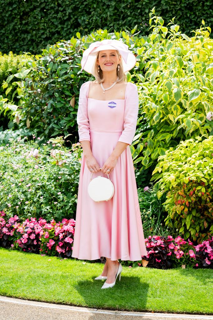 Laura-Ann Barr in a pale pink mid-century inspired dress, wide-brim bow hat and pearls poses for photos in the Royal Ascot garden. (wearing a Sassi Holford dress and a Miss B millinery hat)
