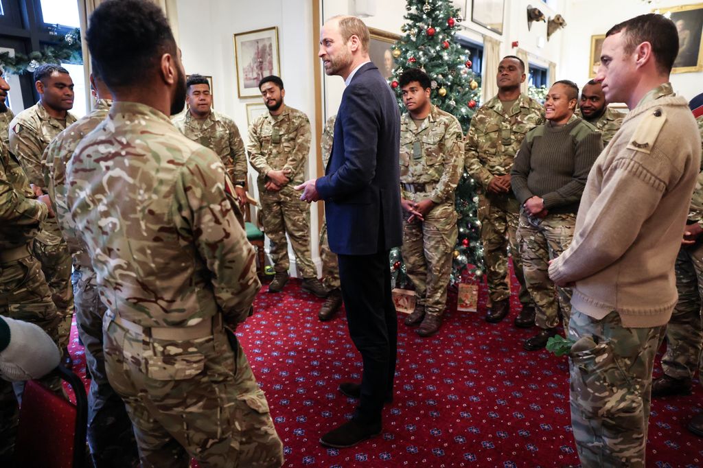 Prince William surrounded by soliders and a Christmas tree