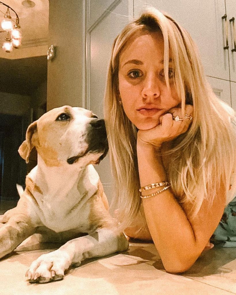 Kaley Cuoco lying on the floor with her dog wearing her engagement ring