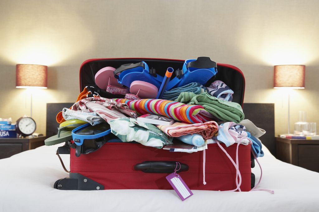 Suitcase of clothes on bed